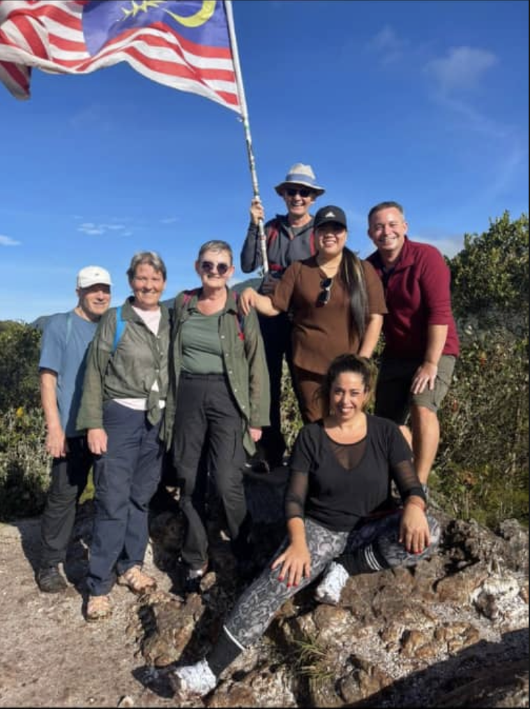 Group at Mount Brinchang peak with Malaysian flag